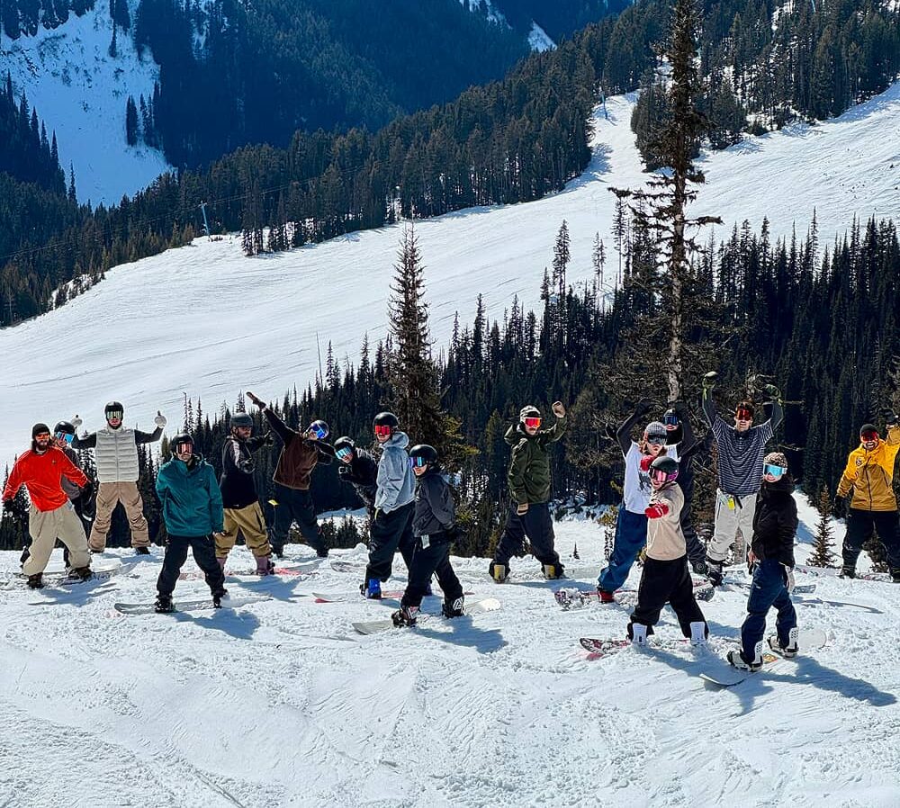 Group of friends smiling and enjoying a snowy day at the Alpine, skiing and snowboarding in Manning Park BC.