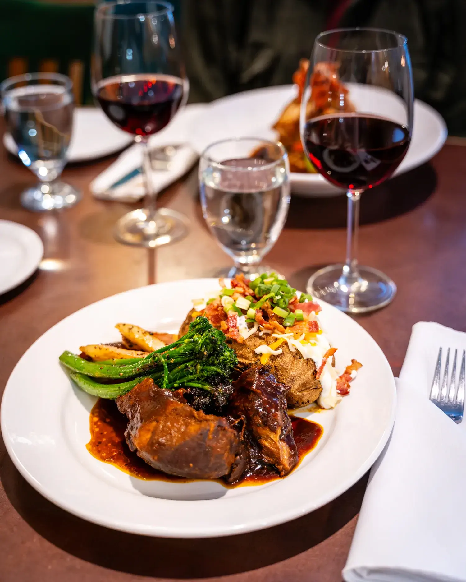 Close-up of a delicious dinner plate and wine glasses at Pinewoods Restaurant, Manning Park Resort.