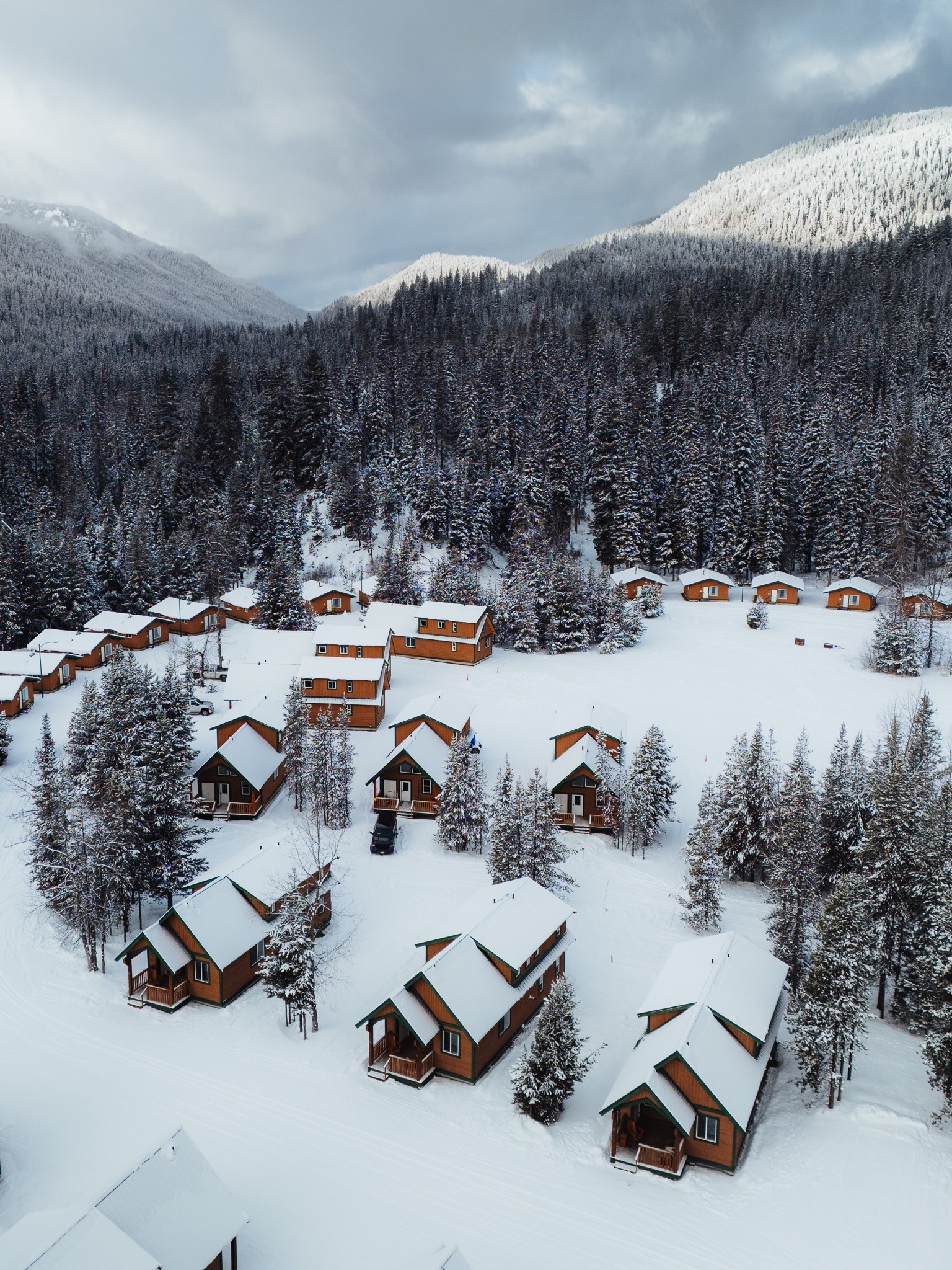 Aerial view of Manning Park Resort cabins covered in winter snow.